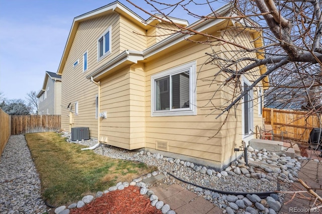 view of home's exterior with central AC unit, a fenced backyard, and crawl space