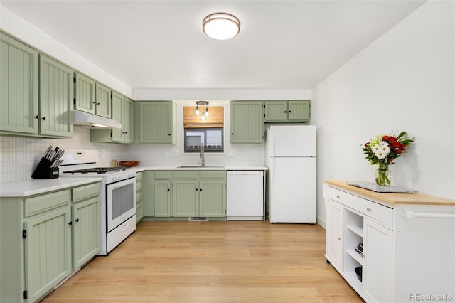 kitchen with green cabinetry, white appliances, light wood-type flooring, and sink