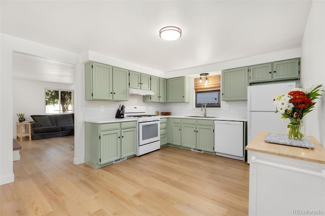 kitchen with green cabinets, white appliances, light hardwood / wood-style flooring, and sink