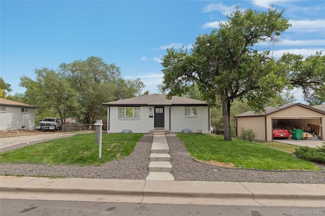 view of front of property featuring a garage, a front lawn, a carport, and an outdoor structure