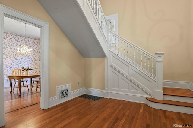 additional living space featuring a chandelier and hardwood / wood-style floors