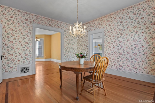 dining area featuring a notable chandelier and hardwood / wood-style floors