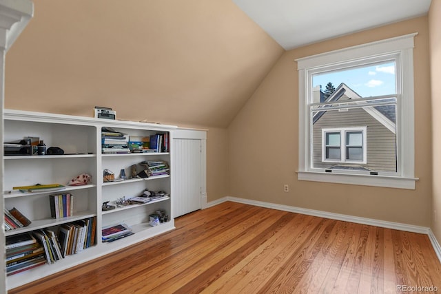 additional living space with vaulted ceiling and light hardwood / wood-style floors