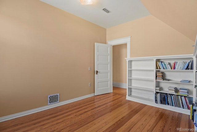 interior space with hardwood / wood-style floors and vaulted ceiling