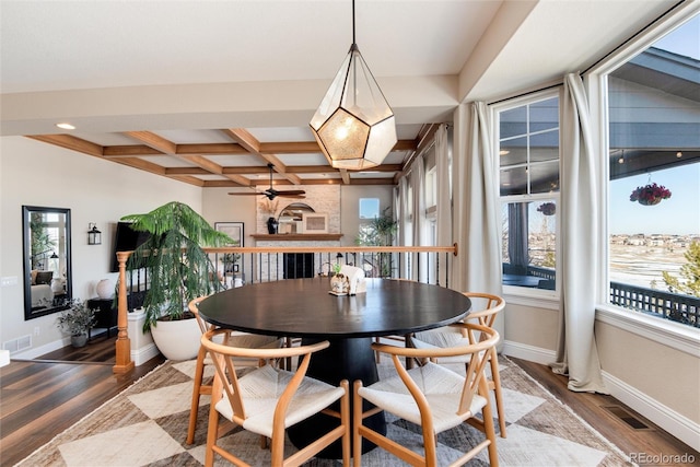 dining room featuring coffered ceiling, hardwood / wood-style flooring, beam ceiling, and ceiling fan