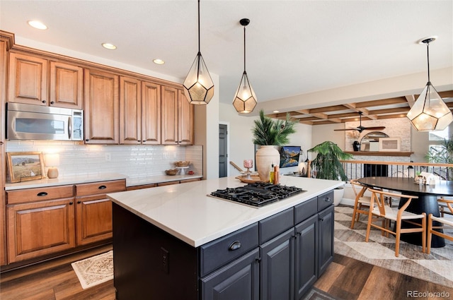 kitchen featuring appliances with stainless steel finishes, dark wood-type flooring, pendant lighting, and backsplash