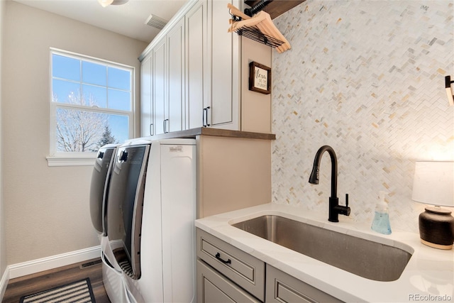 laundry room with cabinets, dark hardwood / wood-style flooring, sink, and independent washer and dryer