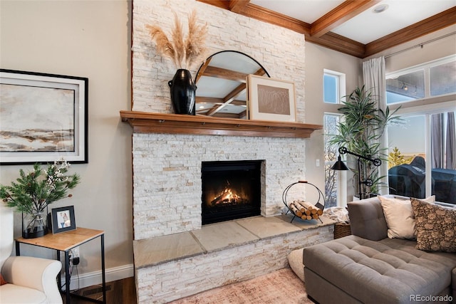 living room with a stone fireplace, hardwood / wood-style floors, and beam ceiling