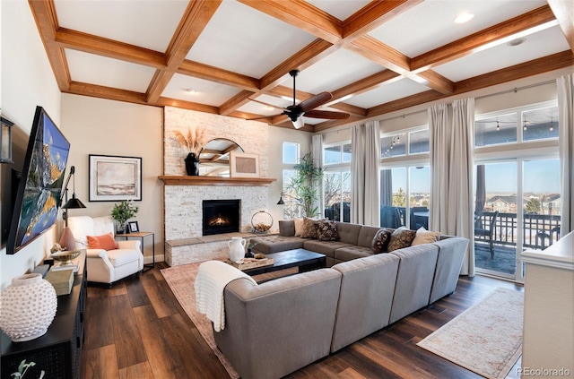 living room with a stone fireplace, coffered ceiling, and dark hardwood / wood-style floors