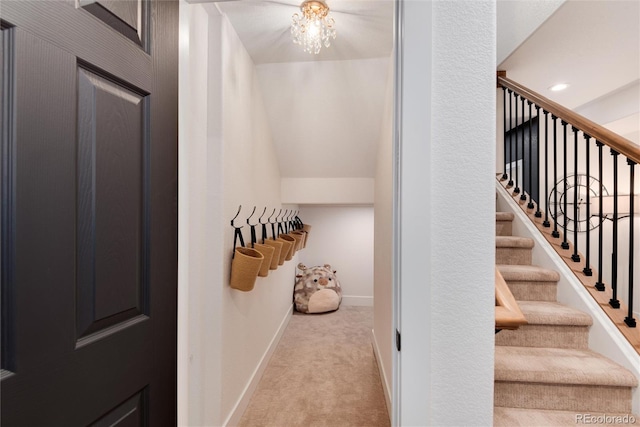 stairway with carpet flooring and a notable chandelier