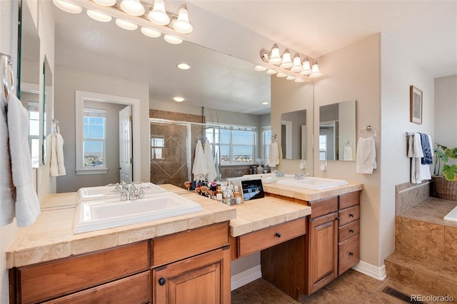 bathroom with a shower with door, vanity, and tile patterned flooring