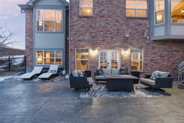 rear view of property featuring brick siding, fence, an outdoor living space, and a patio area