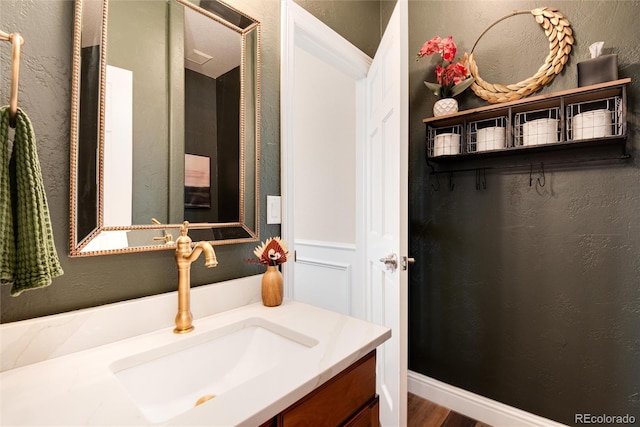 27319 E Nova Cir, Aurora, CO 80016 - bathroom with vanity, a textured wall, a spacious closet, and wood finished floors