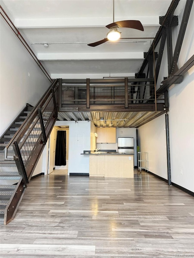 1111 Osage St Unit 7, Denver, CO 80204 - unfurnished living room featuring wood finished floors, baseboards, a ceiling fan, beamed ceiling, and stairs