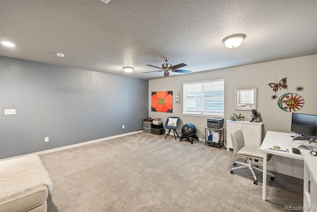 office area with light carpet, ceiling fan, and a textured ceiling