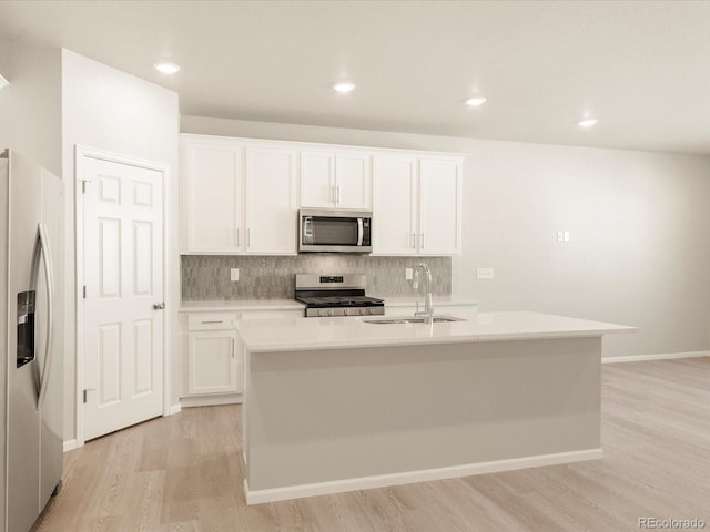 kitchen featuring stainless steel appliances, sink, a center island with sink, and white cabinets