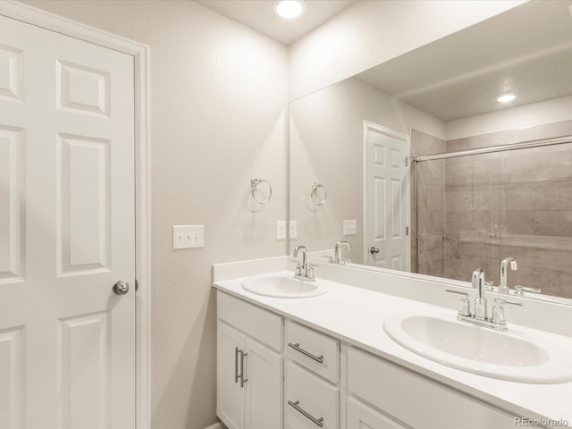 bathroom featuring a shower with door and vanity