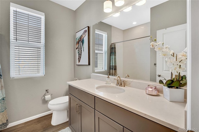 21436 E Stanford Ave, Aurora, CO 80015 - bathroom featuring a tile shower, vanity, toilet, baseboards, and wood finished floors