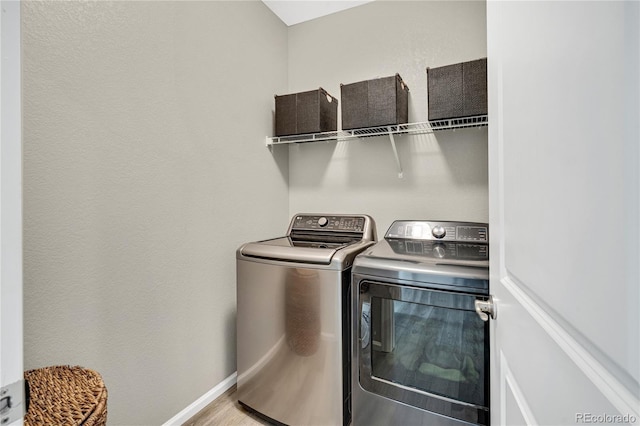 21436 E Stanford Ave, Aurora, CO 80015 - washroom with baseboards, laundry area, wood finished floors, and washer and clothes dryer
