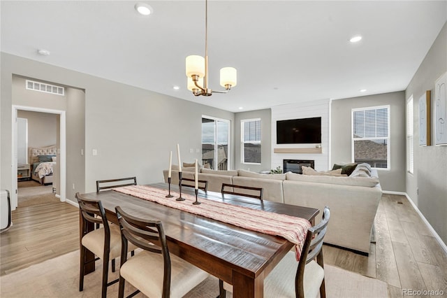 21436 E Stanford Ave, Aurora, CO 80015 - dining room with visible vents, light wood finished floors, baseboards, and an inviting chandelier