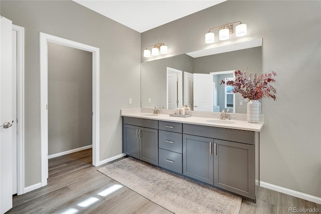 21436 E Stanford Ave, Aurora, CO 80015 - full bath with a sink, baseboards, double vanity, and wood finished floors