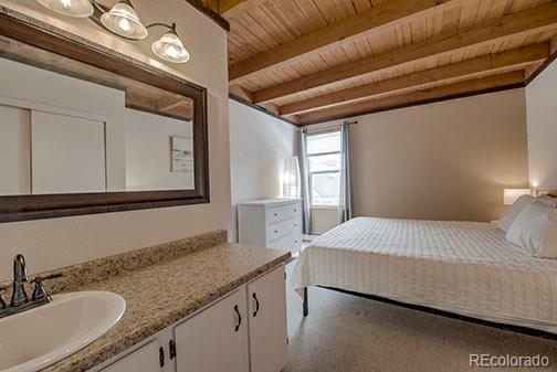 8500 Ryan Gulch Rd Unit 101, Silverthorne, CO 80498 - bedroom featuring a sink, wood ceiling, and beamed ceiling