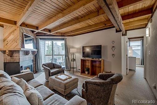 8500 Ryan Gulch Rd Unit 101, Silverthorne, CO 80498 - living area with a fireplace, beamed ceiling, wooden ceiling, and carpet