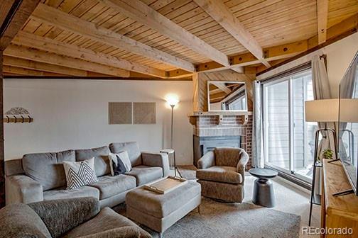 8500 Ryan Gulch Rd Unit 101, Silverthorne, CO 80498 - living room with beamed ceiling, wood ceiling, and a fireplace