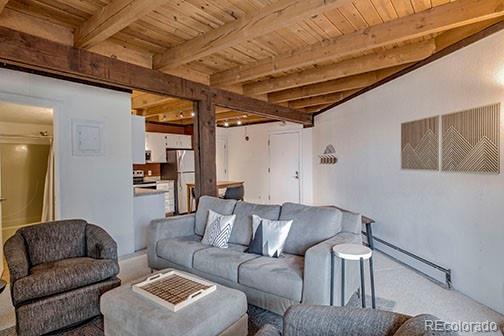8500 Ryan Gulch Rd Unit 101, Silverthorne, CO 80498 - living area with wooden ceiling, a baseboard radiator, and beam ceiling