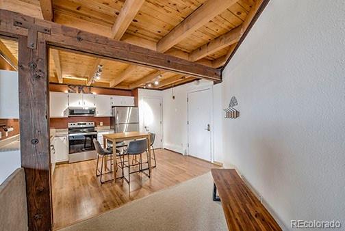 8500 Ryan Gulch Rd Unit 101, Silverthorne, CO 80498 - dining space with wooden ceiling, beamed ceiling, and light wood-style floors