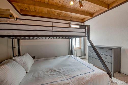 8500 Ryan Gulch Rd Unit 101, Silverthorne, CO 80498 - carpeted bedroom featuring wooden ceiling and beamed ceiling