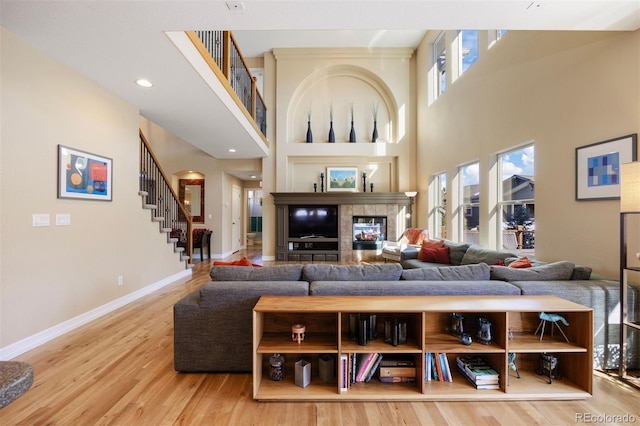 living room with a high ceiling, hardwood / wood-style floors, and a fireplace