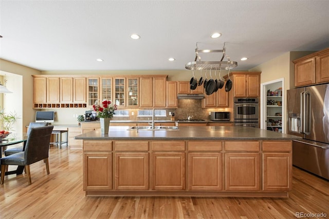 kitchen featuring light hardwood / wood-style floors, sink, stainless steel appliances, and a kitchen island with sink