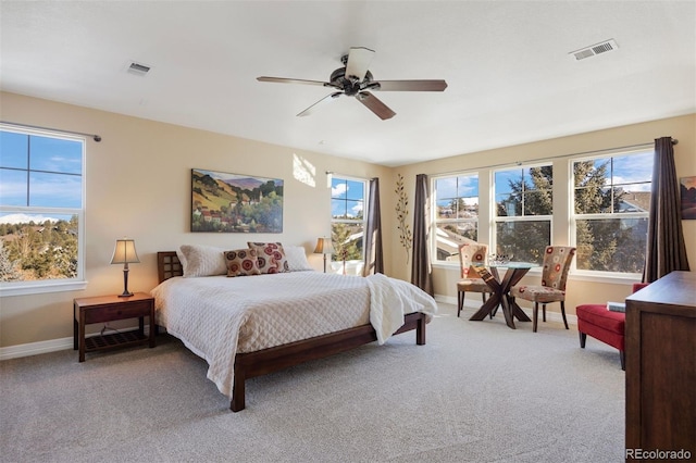 carpeted bedroom with ceiling fan and multiple windows