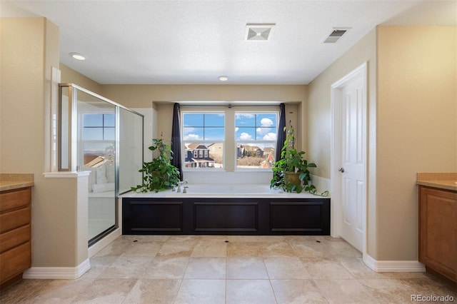 interior space featuring vanity and shower with separate bathtub