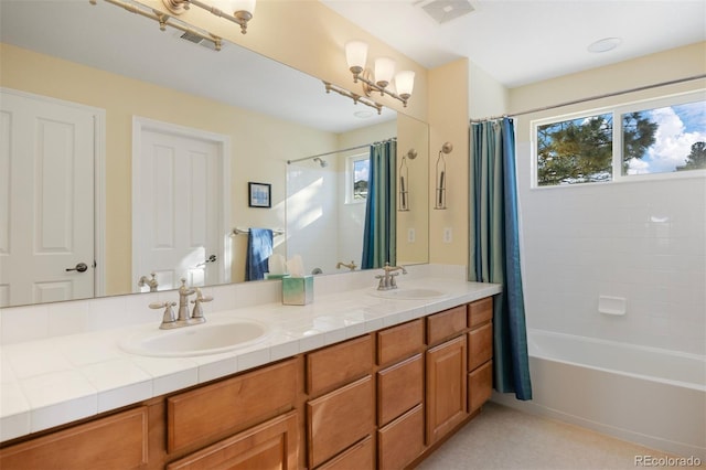 bathroom with vanity, shower / bath combo, and a healthy amount of sunlight