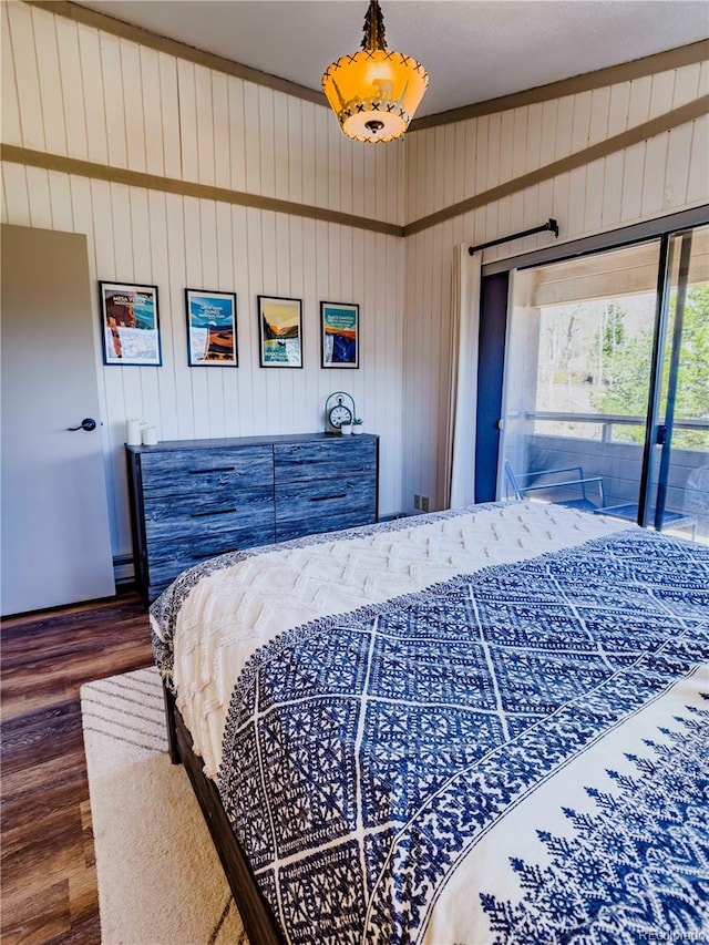 bedroom featuring access to outside, wood finished floors, and wooden walls