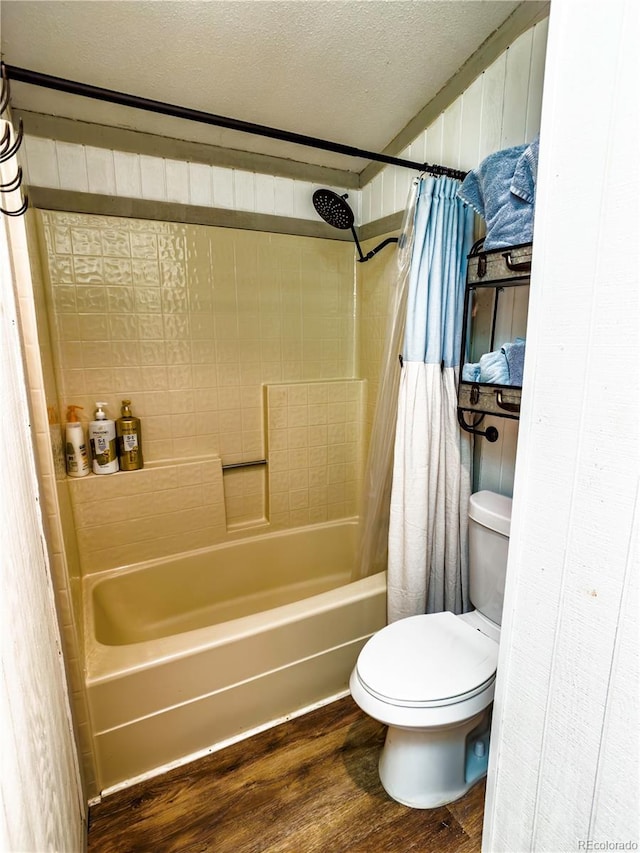 full bathroom with toilet, shower / tub combo with curtain, wood finished floors, and a textured ceiling