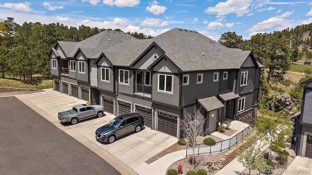 31191 Black Eagle Dr Unit 304, Evergreen, CO 80439 - view of front of home with driveway, a garage, stone siding, and roof with shingles