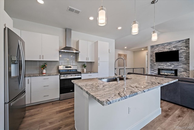 31191 Black Eagle Dr Unit 304, Evergreen, CO 80439 - kitchen with stainless steel appliances, wall chimney exhaust hood, a sink, dark wood finished floors, and open floor plan