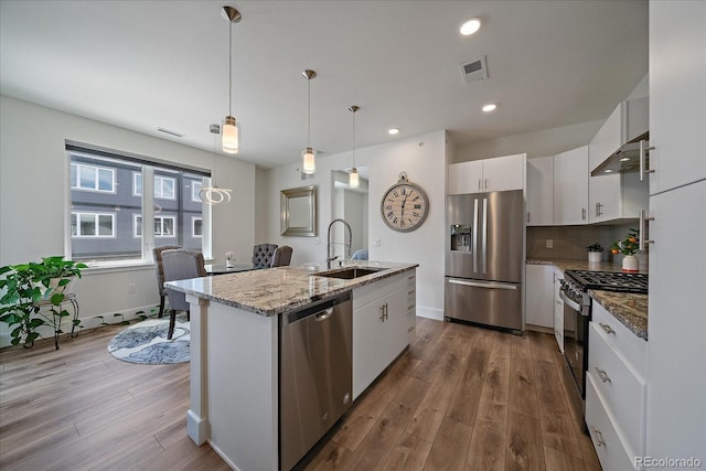 31191 Black Eagle Dr Unit 304, Evergreen, CO 80439 - kitchen featuring stainless steel appliances, a sink, white cabinets, dark wood-style flooring, and under cabinet range hood