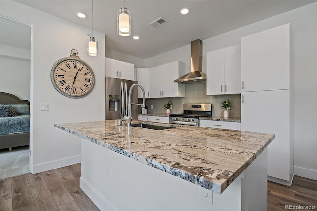 31191 Black Eagle Dr Unit 304, Evergreen, CO 80439 - kitchen featuring appliances with stainless steel finishes, wall chimney exhaust hood, a sink, wood finished floors, and baseboards