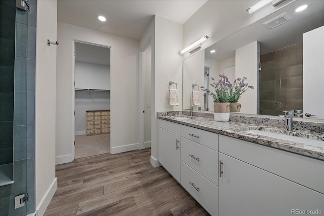 31191 Black Eagle Dr Unit 304, Evergreen, CO 80439 - bathroom featuring double vanity, a shower stall, wood finished floors, baseboards, and recessed lighting