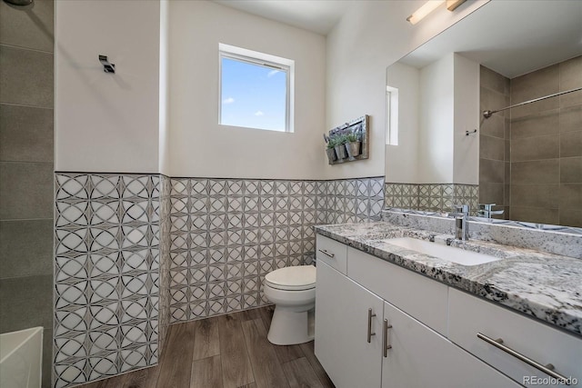 31191 Black Eagle Dr Unit 304, Evergreen, CO 80439 - full bath featuring tile walls, wood finished floors, toilet, vanity, and a tile shower