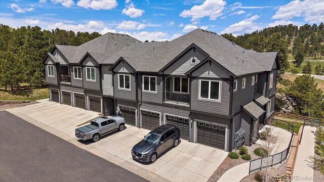 31191 Black Eagle Dr Unit 304, Evergreen, CO 80439 - view of front of home featuring driveway, an attached garage, and roof with shingles