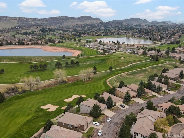 drone / aerial view with a residential view, golf course view, and a water and mountain view