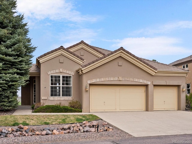 mediterranean / spanish-style house featuring an attached garage, stucco siding, and driveway