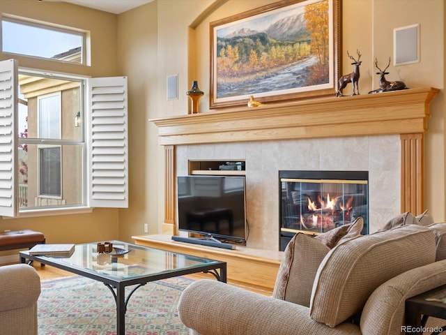 living area featuring a tile fireplace and wood finished floors