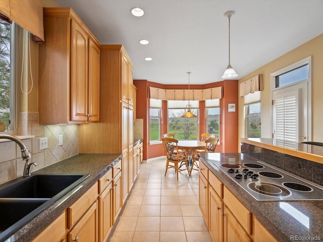 kitchen with backsplash, pendant lighting, a sink, black electric stovetop, and light tile patterned flooring