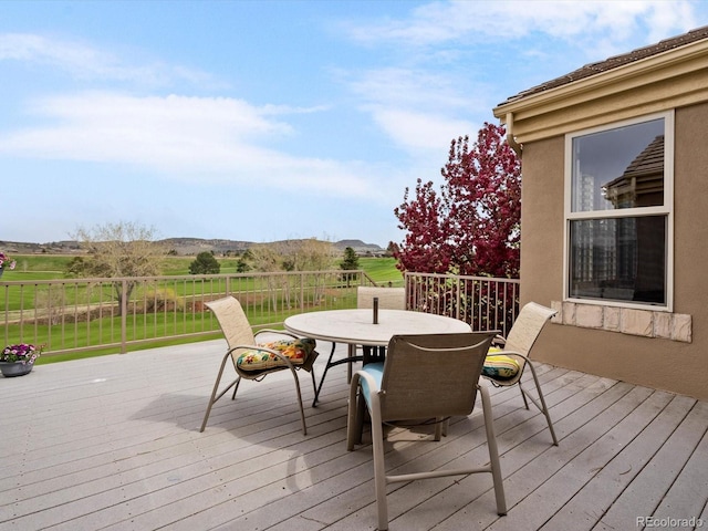 wooden deck featuring fence, a mountain view, and outdoor dining area